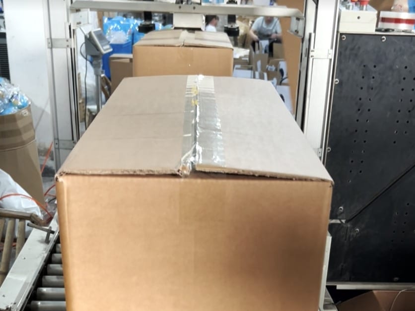 Sealed carton moving on the packing conveyor